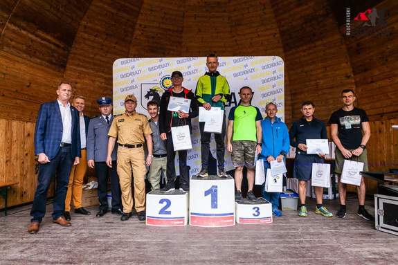 na zdjęciu uczestnicy zawodów na podium, obok inne osoby