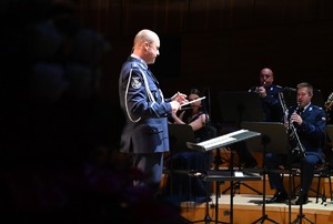 Zdjęcie przedstawia dyrygenta oraz orkiestrę