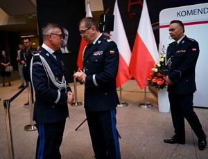 Zdjęcie przedstawia trzech policjantów stojących na korytarzu