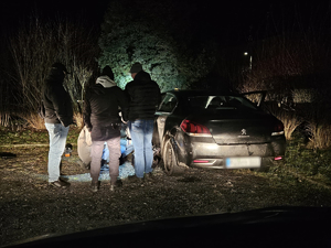 Na zdjęciu nieumundurowani policjanci przy odzyskanym, skradzionym wcześniej samochodzie.