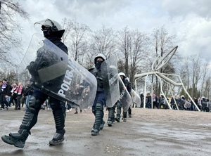 Umundurowani policjanci eskortujący kibiców