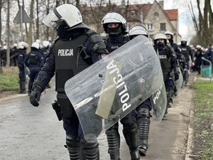 Umundurowani policjanci eskortujący kibiców podczas zabezpieczenia