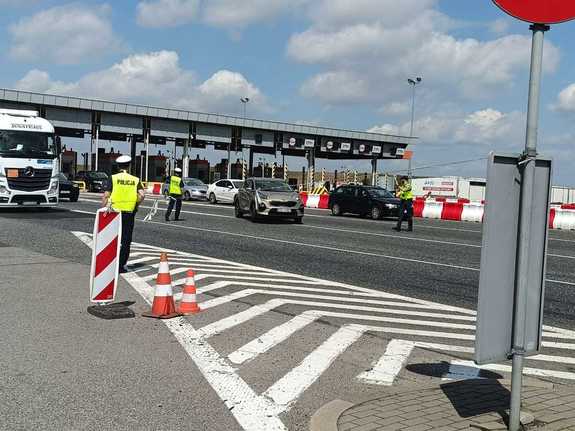 Zdjęcie trzech policjantów w trakcie kontroli pojazdów.