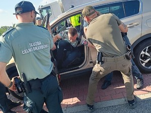 Zdjęcie przedstawiające funkcjonariuszy w trakcie ćwiczeń, wyprowadzających osobę zatrzymaną z pojazdu.