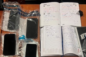 na zdjęciu notatnik oraz zabezpieczone telefony komórkowe