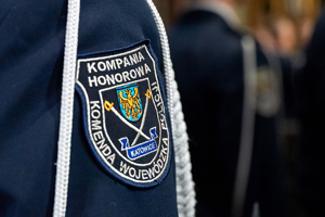 kolorowe zdjęcie przedramienia policjanta na którym znajduje się emblemat naramienny kompani honorowej