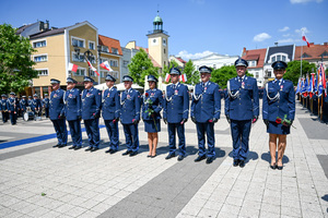 kolorowe zdjęcie przedstawiające policjantów stojących w rzędzie na placu rynku