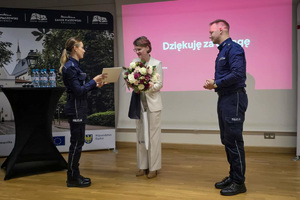 Zdjęcie ukazujące wręczenie kwiatów przez policjantów