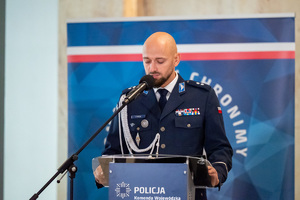 Zdjęcie ukazuje wizerunek przemawiającego policjanta