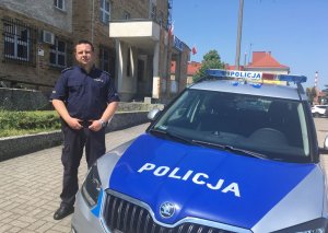 Policjant stoi przy radiowozie