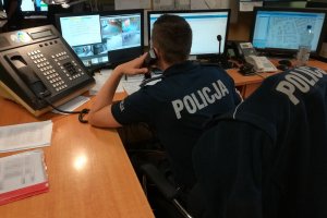 Policjant siedzi przy biurku na dyżurce