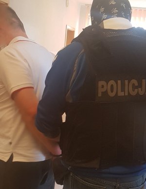 Policjant prowadzi zatrzymanego