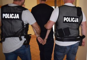 Policjanci prowadzą zatrzymanego