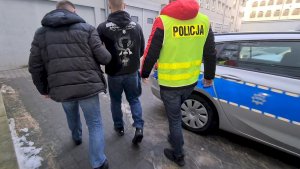 Policjant prowadzi zatrzymanego