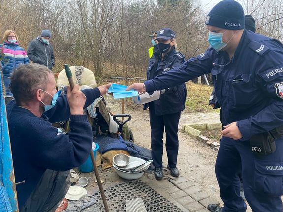 policjanci rozdają paczki żywnościowe potrzebującym