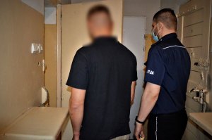 Policjant prowadzi zatrzymanego