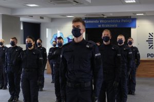 18 policjantów ustawionych  w równych odstępach