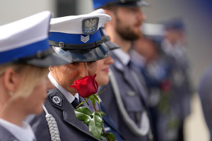 policjantka wącha różę, którą otrzymała podczas gratulowania awansu