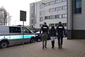 policjanci prowadzą 33-latkę do radiowozu