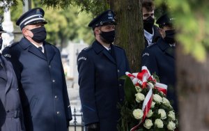 Policjanci składają wieniec na grobie.