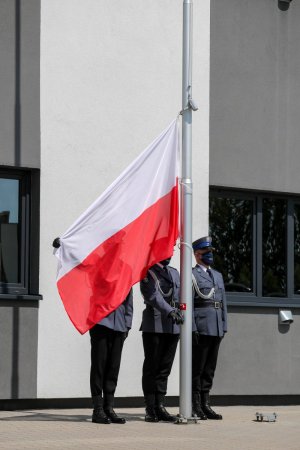 Policjanci zawieszają flagę na maszcie