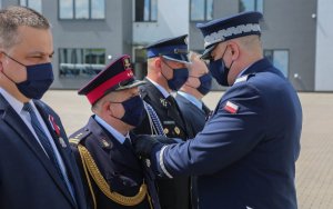 Komendant przypina medal dziesiątemu odznaczonemu