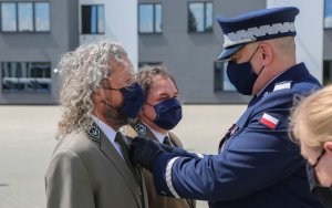 Komendant wręcza medal przedstawicielowi TPN