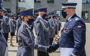 Komendant gratuluje ustawionej w szeregu policjantce awansu