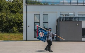 Trzech policjantów wyprowadza sztandar