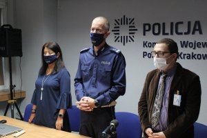 policjanci na sali konferencyjnej. na ścianie widnieje napis Komenda Wojewódzka Policji w Krakowie