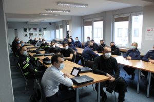 policjanci na sali konferencyjnej. na ścianie widnieje napis Komenda Wojewódzka Policji w Krakowie