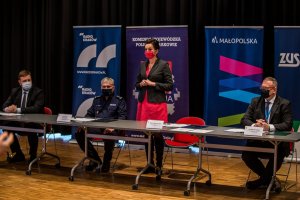 przy stole siedzą przedstawiciele: Radia Kraków, Komendy Wojewódzkiej Policji w Krakowie, Urzędu Małopolskiego i Zakładu Ubezpieczeń Społecznych