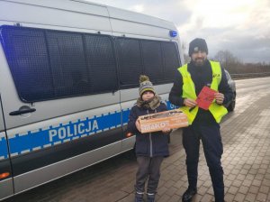 policjanci z chłopcem który przyniósł poczęstunek dla mundurowych