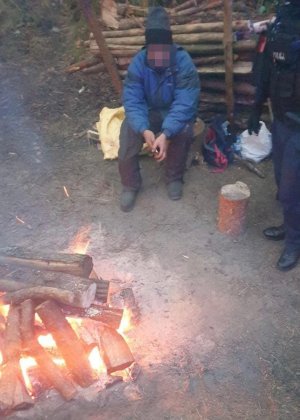 zatrzymany mężczyzna grzeje się przy ognisku
