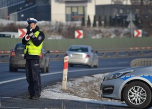 policjant ruchu drogowego mierzy prędkość na drodze