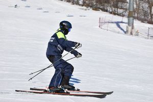 policjant w patrolu narciarskim jadący na nartach