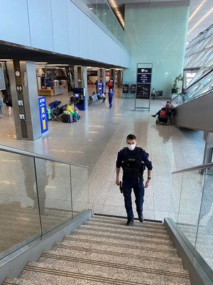 policjant patrolujący teren wnętrza budynku lotniska podczas wchodzenia po schodach