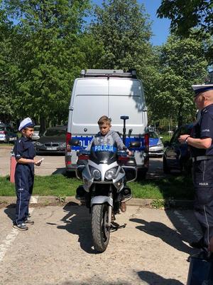 Chłopiec siedzi na motorze policyjnym