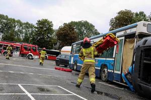 Strażak biegnie z noszami do autobusu