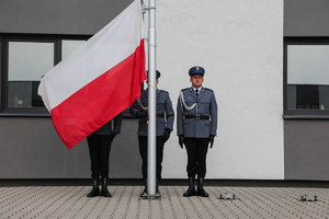 policjanci pocztu wieszają flagę na maszt