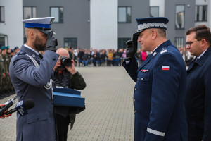 Policjant odznaczony i komendant wojewódzki salutują w swoją stronę