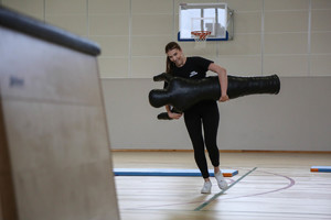 uczennica klasy mundurowej biegnie z manekinem