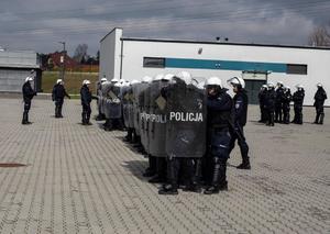 Policjanci Nieetatowych Pododdziałów Prewencji idący w tyralierze, na w pierwszej linii idą funkcjonariusze trzymający tarcze przeciwuderzeniowe