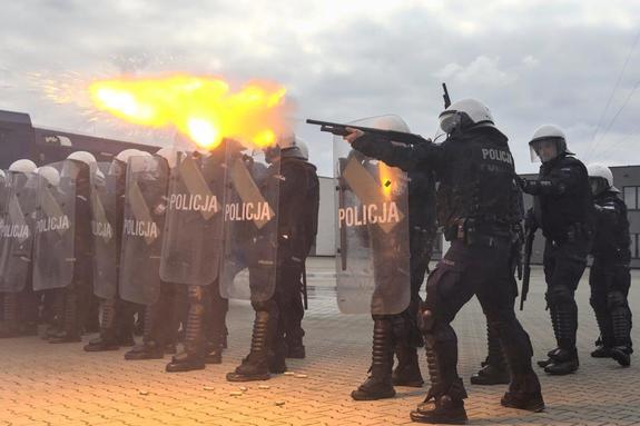 policjant strzelający ze strzelby gładkolufowej