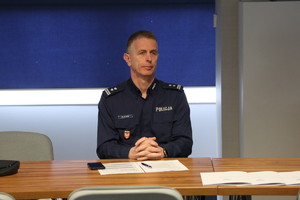 policjant na sali odpraw siedzący na spotkaniu roboczym w sprawie Odblaskowej szkoły