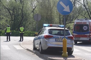 zabezpieczenie 83 rocznica Pierwszego transportu do Auschwitz 14.06.2023  (4) policjanci na skrzyżowaniu obok radiowóz i karetka