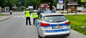 policjanci ruchu drogowego przy radiowozie