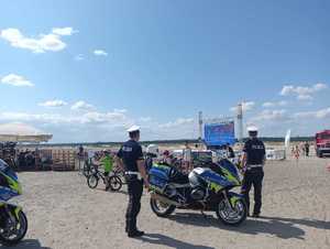 Dwaj policjnci ruchu drogowego z motoccyklami  na terenie Pustyni Błędowskiej w strefi kibica.