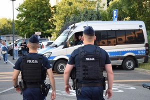 dwóch umundurowanych policjantów patrolujących rejon stadionu na ul. Reymonta idących w kierunku radiowozu