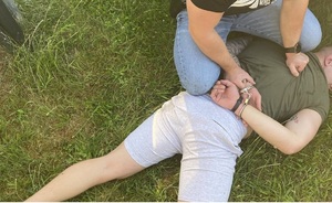 zatrzymany  na ziemi  jest przytrzymany przez policjanta